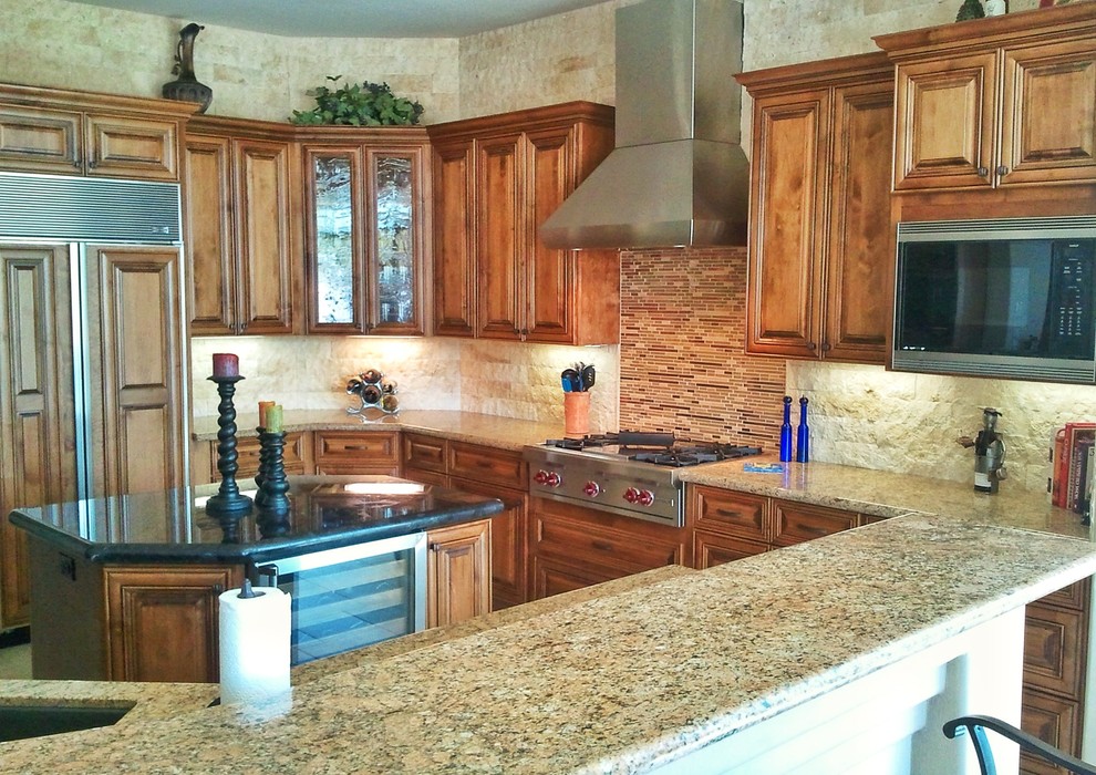 This is an example of a mid-sized traditional u-shaped open plan kitchen in Phoenix with an undermount sink, raised-panel cabinets, medium wood cabinets, granite benchtops, beige splashback, stone tile splashback, panelled appliances, travertine floors, with island, beige floor and beige benchtop.