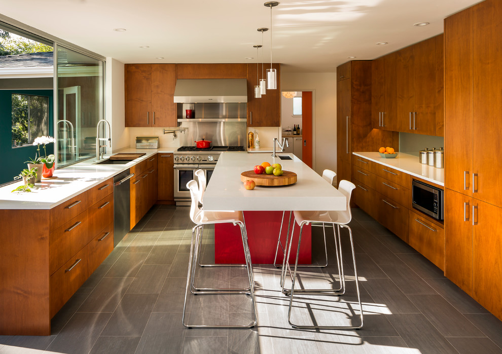 Design ideas for a mid-sized contemporary u-shaped kitchen in San Francisco with flat-panel cabinets, medium wood cabinets, stainless steel appliances, an undermount sink, quartz benchtops, porcelain floors, with island, metallic splashback and grey floor.