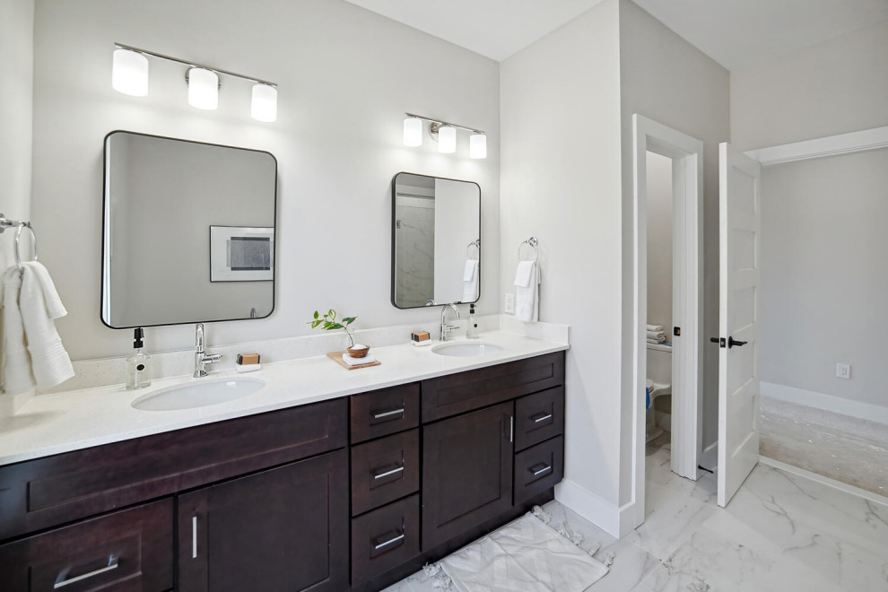 Photo of a large transitional master bathroom in DC Metro with shaker cabinets, brown cabinets, an undermount tub, a corner shower, engineered quartz benchtops, a hinged shower door, white benchtops, an enclosed toilet, a double vanity and a built-in vanity.