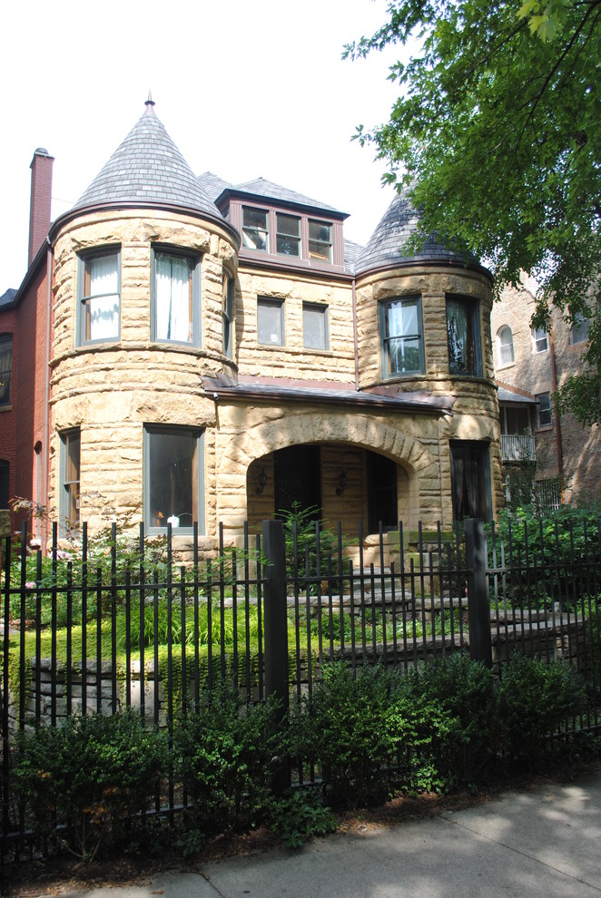 Photo of a mid-sized traditional two-storey beige house exterior in Chicago with stone veneer and a shingle roof.