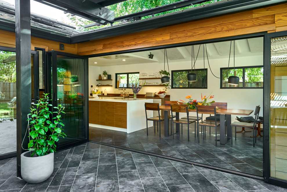 Foto di una sala da pranzo aperta verso la cucina minimalista di medie dimensioni con pareti bianche, pavimento in gres porcellanato, pavimento grigio, soffitto a volta e pareti in legno