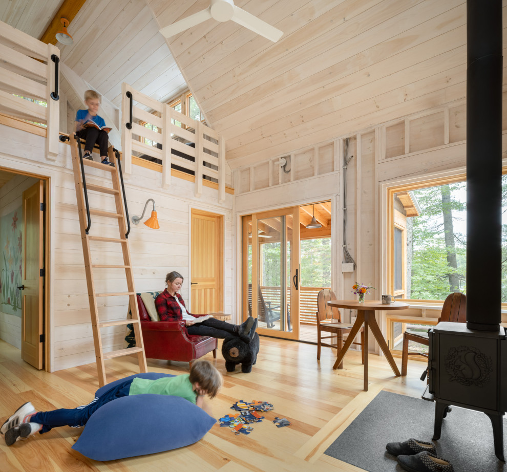 Uriges Wohnzimmer mit beiger Wandfarbe, hellem Holzboden, beigem Boden, gewölbter Decke, Holzdecke und Holzwänden in Portland Maine