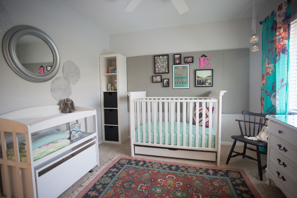 This is an example of a small eclectic nursery for girls in San Diego with grey walls and carpet.