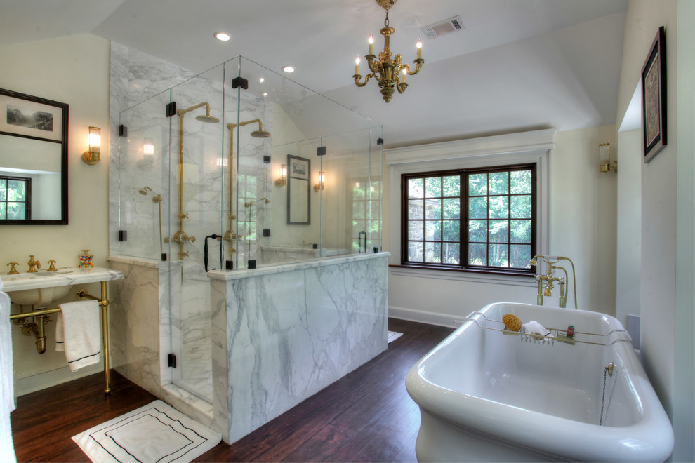 This is an example of a country bathroom in New York with a console sink, a freestanding tub, a double shower and marble.