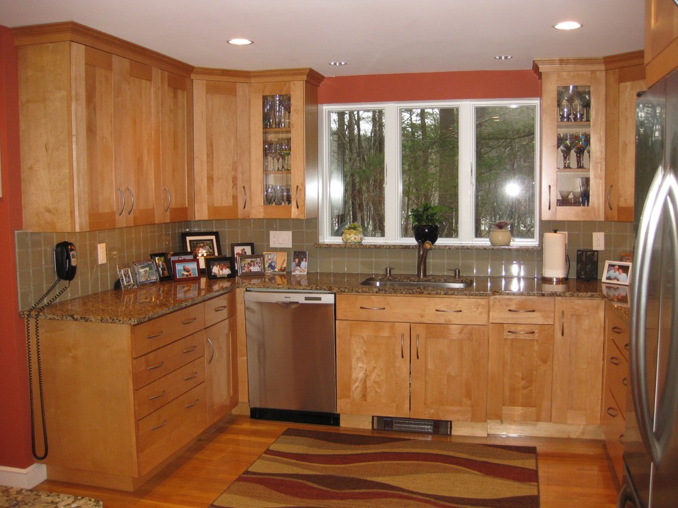 Example of a transitional u-shaped medium tone wood floor eat-in kitchen design in Boston with an undermount sink, shaker cabinets, light wood cabinets, granite countertops, beige backsplash, glass tile backsplash, stainless steel appliances and an island