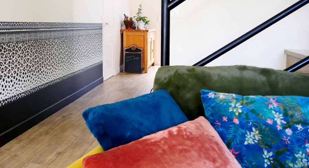 This is an example of a large foyer in Paris with white walls, laminate floors and beige floor.