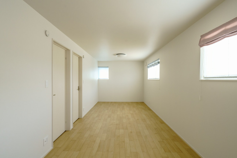 Immagine di una cameretta per bambini da 4 a 10 anni minimalista di medie dimensioni con pareti bianche, parquet chiaro, pavimento beige, soffitto in carta da parati e carta da parati