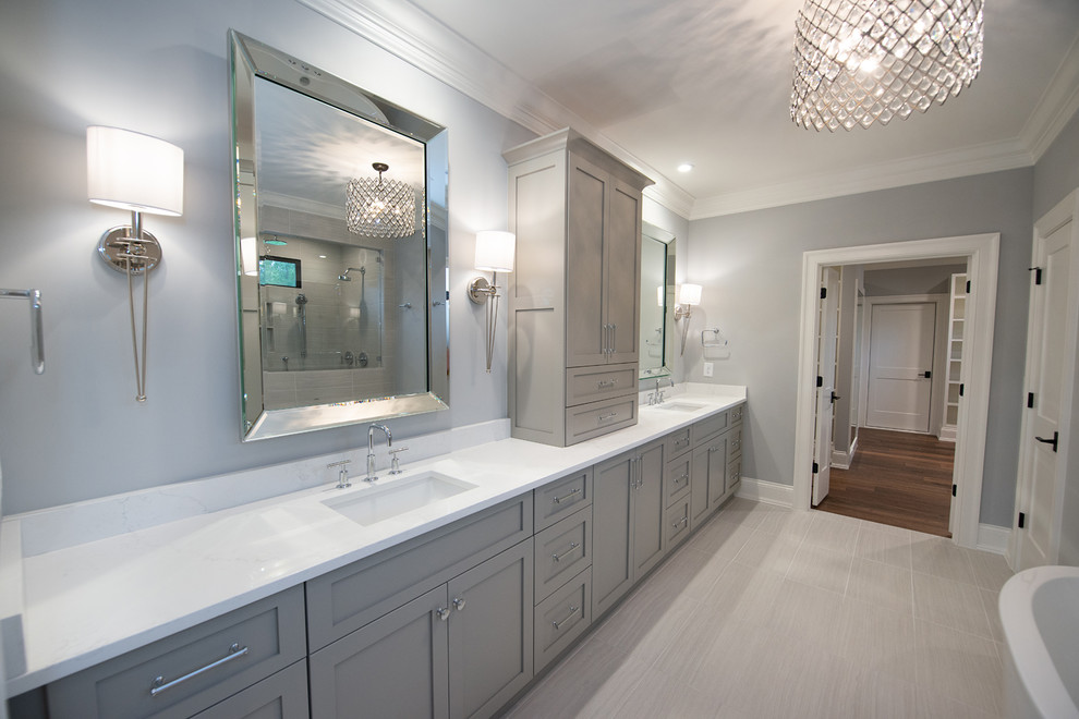 Design ideas for a contemporary master bathroom in Raleigh with shaker cabinets, grey cabinets, a freestanding tub, an open shower, gray tile, porcelain tile, grey walls, porcelain floors, an undermount sink, engineered quartz benchtops, grey floor, an open shower and white benchtops.