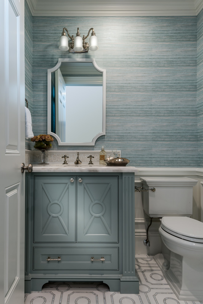 Inspiration for a transitional powder room in Los Angeles with beaded inset cabinets, blue cabinets, a two-piece toilet, blue tile, blue walls, an undermount sink, white floor and white benchtops.