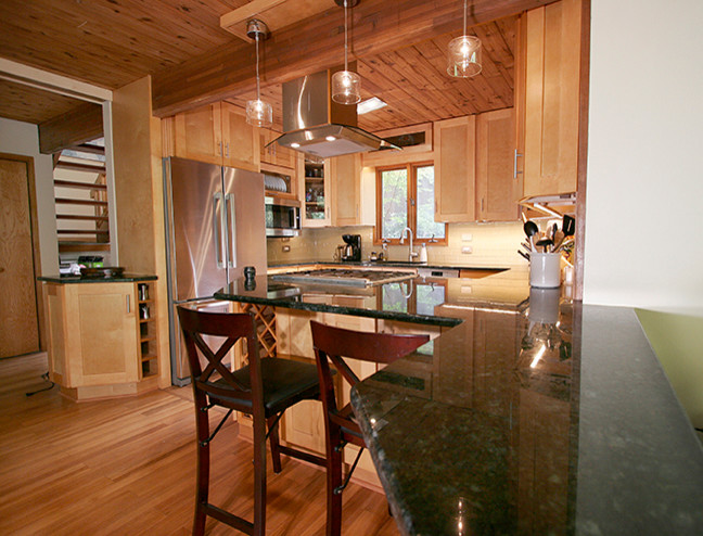Eat-in kitchen - small transitional l-shaped porcelain tile eat-in kitchen idea with shaker cabinets, light wood cabinets, granite countertops, beige backsplash, glass tile backsplash, stainless steel appliances and a peninsula