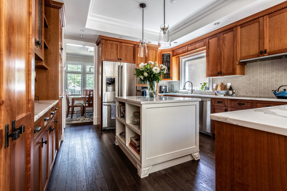 Photo of a mid-sized arts and crafts u-shaped kitchen in Vancouver with shaker cabinets, medium wood cabinets, grey splashback, mosaic tile splashback, stainless steel appliances, dark hardwood floors, with island, brown floor, white benchtop and recessed.