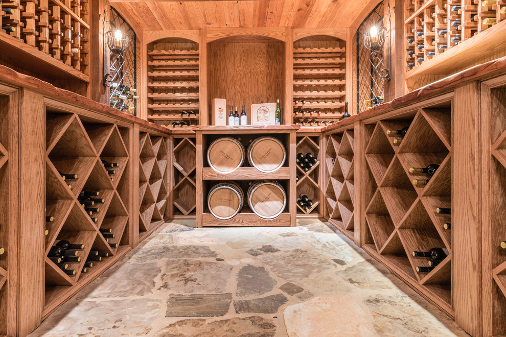 Inspiration for a mid-sized country wine cellar in Austin with limestone floors and diamond bins.
