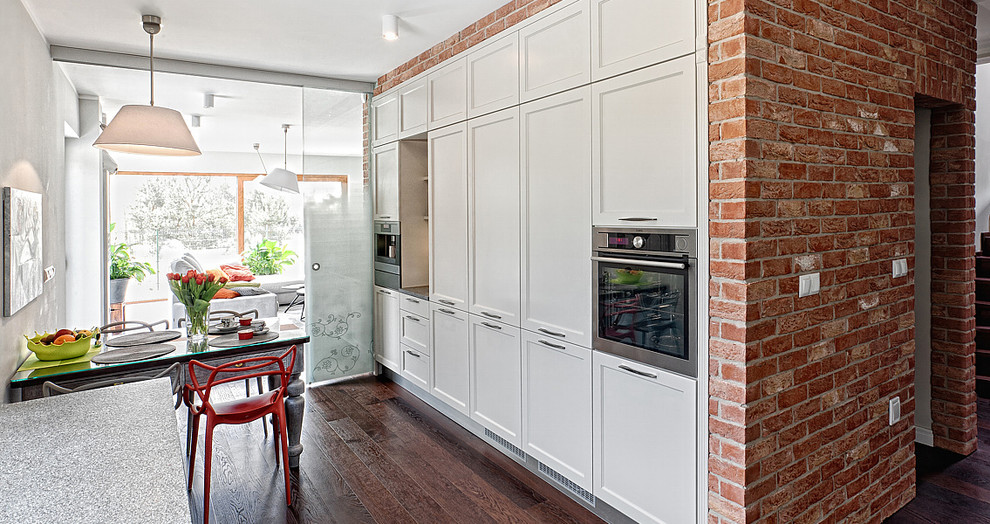 Inspiration for an expansive rustic l-shaped kitchen/diner in Glasgow with an integrated sink, shaker cabinets, white cabinets, wood worktops, beige splashback, stainless steel appliances and dark hardwood flooring.