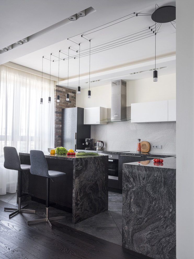 Photo of a mid-sized contemporary l-shaped open plan kitchen in Moscow with granite benchtops, grey splashback, porcelain splashback, porcelain floors, with island, grey floor, flat-panel cabinets, black cabinets and black benchtop.