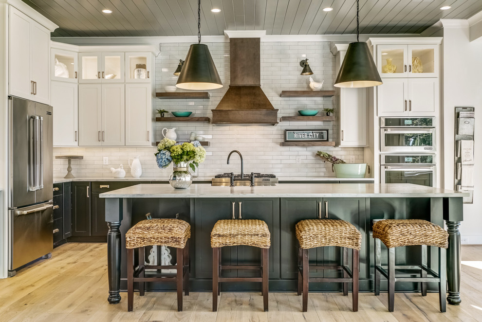 Inspiration for a country l-shaped kitchen in Other with marble benchtops, white splashback, stainless steel appliances, light hardwood floors, with island, white benchtop, shaker cabinets, white cabinets and subway tile splashback.