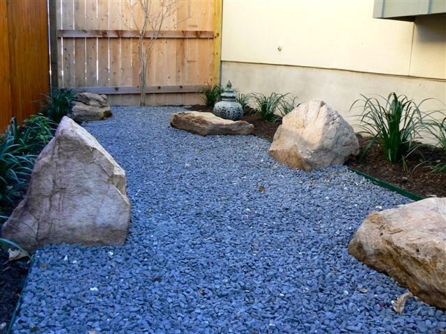 Side yard; Texas black gravel design with small boulders