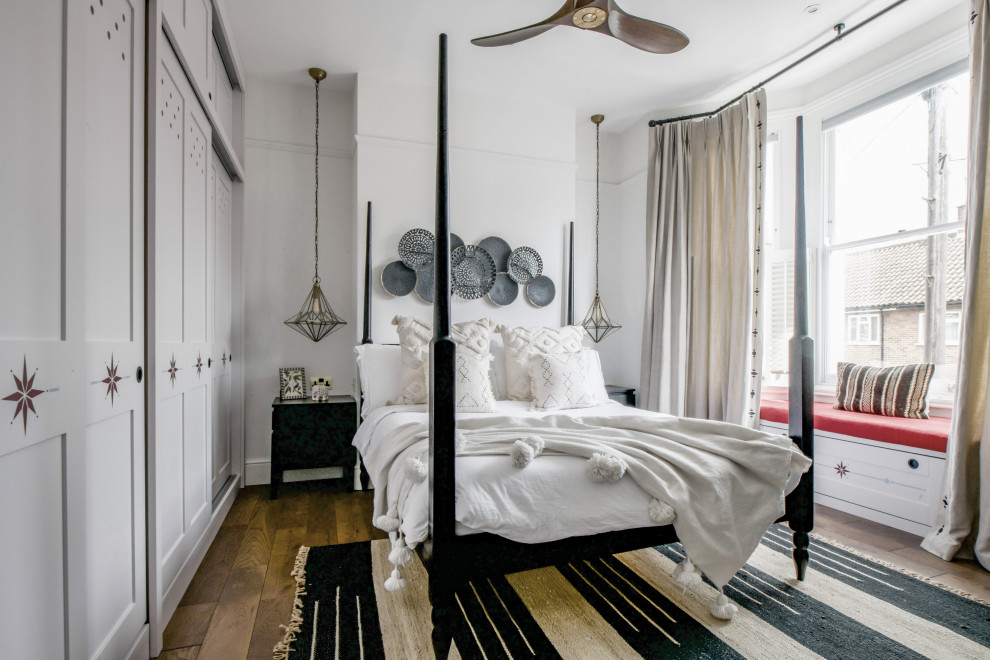 Inspiration for a traditional bedroom in London with white walls, dark hardwood flooring and brown floors.