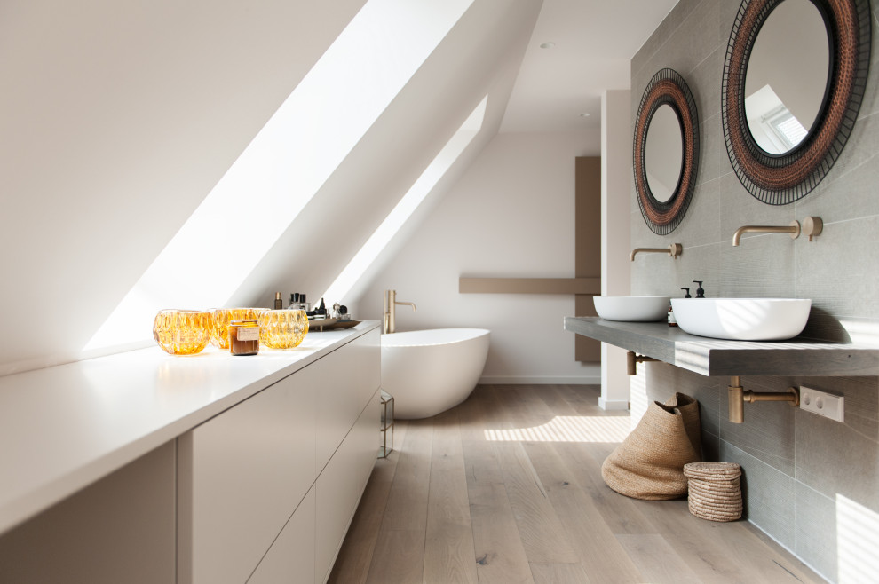 Example of a mid-sized trendy master beige tile and stone tile single-sink bathroom design in Berlin with shaker cabinets, white cabinets, a wall-mount toilet, white walls, black countertops and a floating vanity