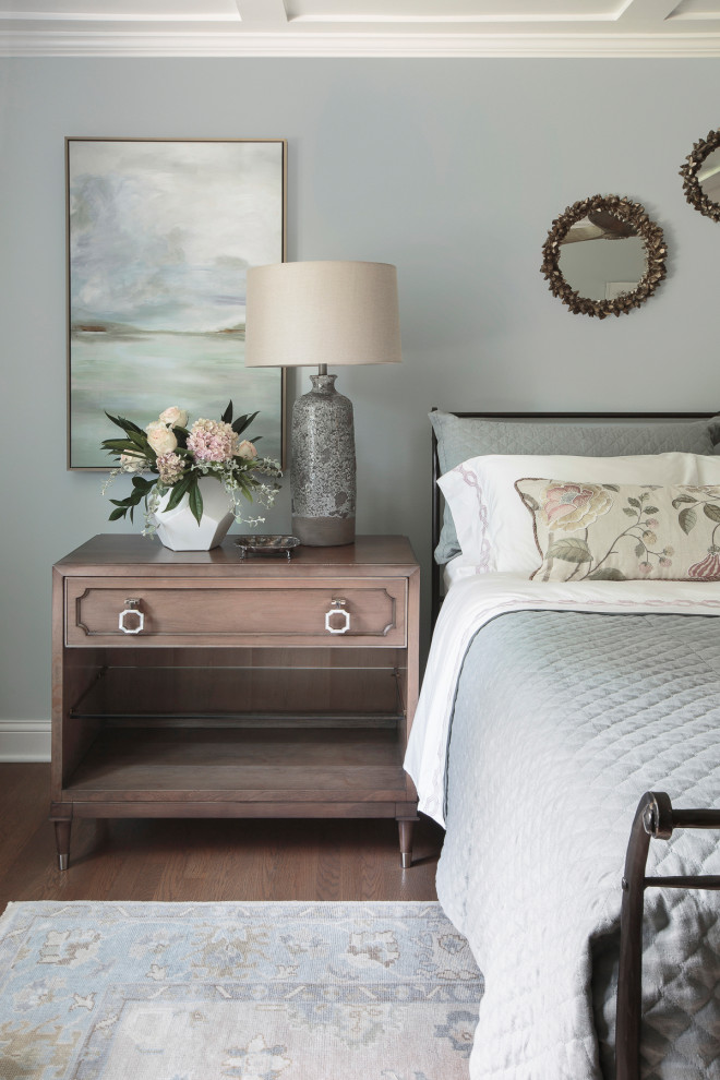 Ejemplo de dormitorio principal tradicional de tamaño medio con paredes azules, suelo de madera en tonos medios, suelo marrón y casetón