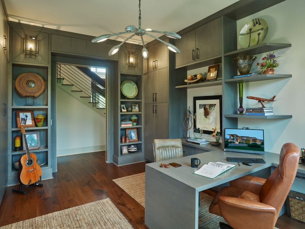 Transitional home office in Nashville with white walls, dark hardwood floors, a built-in desk and brown floor.