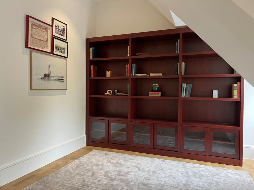 Medium sized midcentury study in London with white walls, light hardwood flooring and a built-in desk.