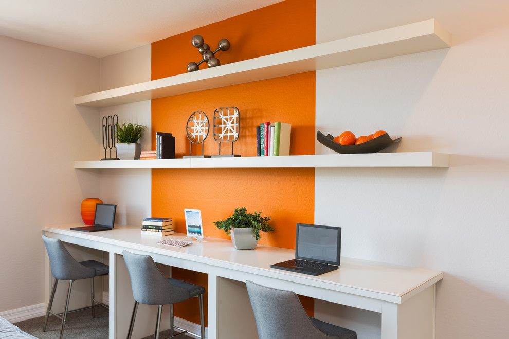 Photo of a transitional study room in Phoenix with orange walls, a built-in desk and grey floor.
