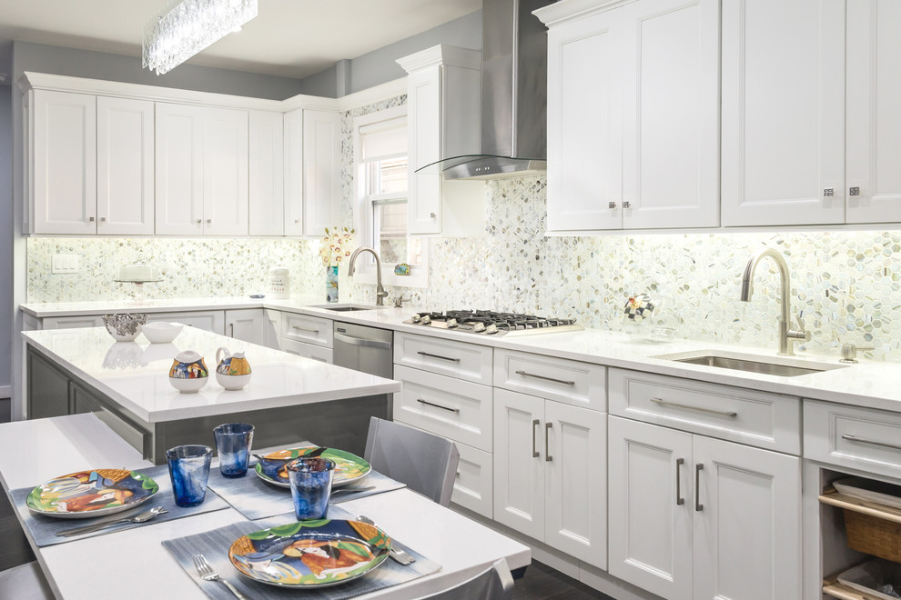 Photo of a mid-sized transitional eat-in kitchen in New York with an undermount sink, shaker cabinets, white cabinets, quartz benchtops, multi-coloured splashback, mosaic tile splashback, stainless steel appliances and with island.