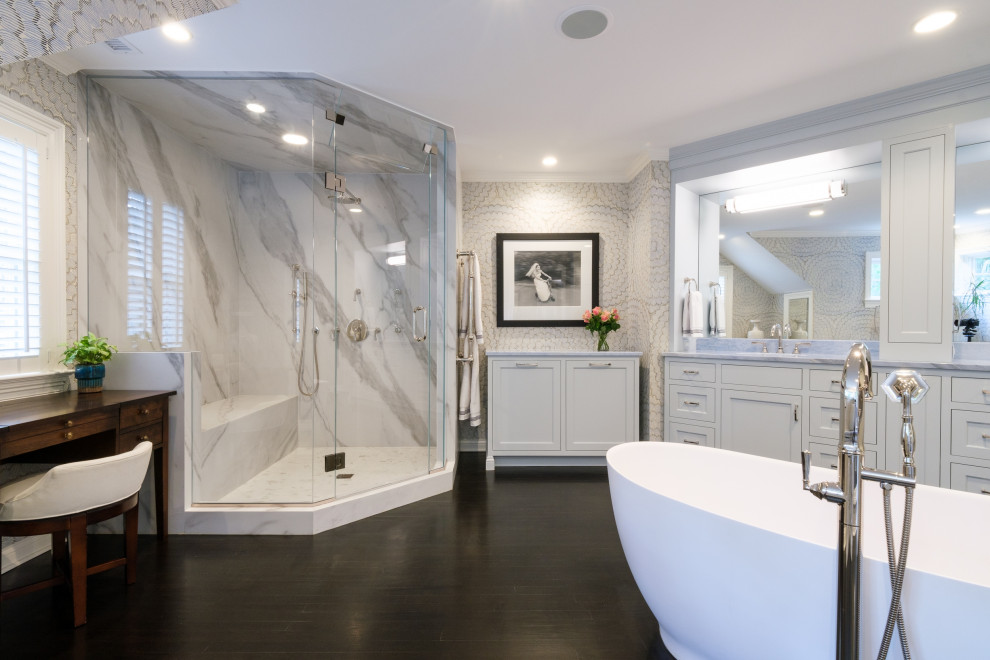 Design ideas for an expansive transitional master bathroom in New York with recessed-panel cabinets, grey cabinets, a freestanding tub, a double shower, multi-coloured walls, dark hardwood floors, an undermount sink, marble benchtops, a hinged shower door, blue benchtops, an enclosed toilet, a double vanity, a built-in vanity and wallpaper.