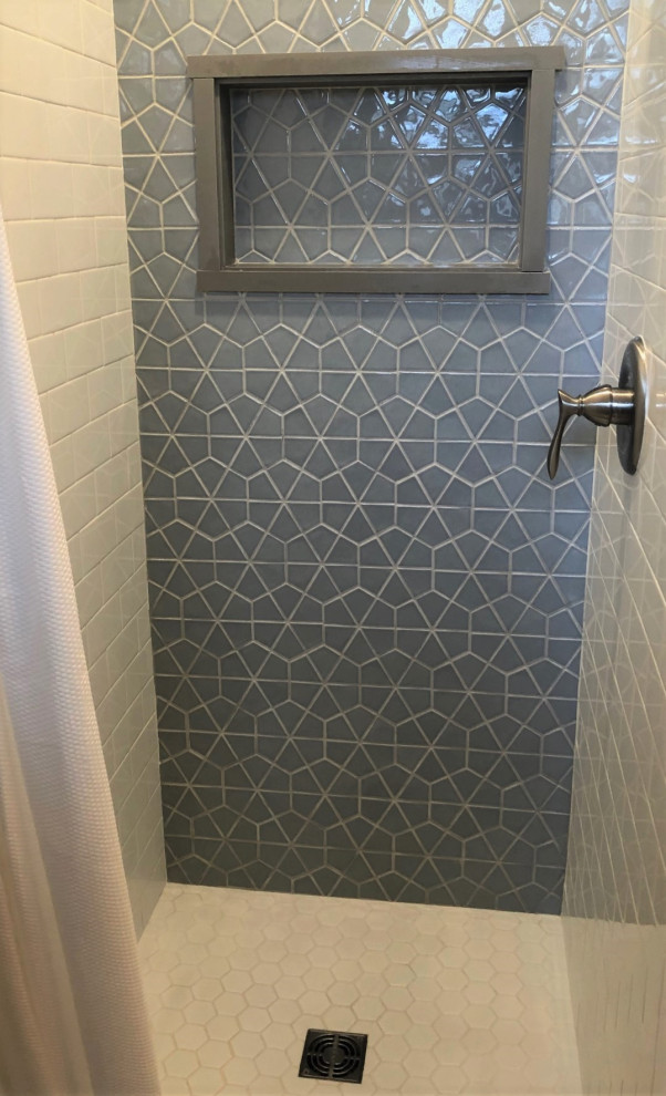 Photo of a small contemporary 3/4 bathroom in Other with recessed-panel cabinets, grey cabinets, an alcove shower, white tile, subway tile, grey walls, vinyl floors, an undermount sink, granite benchtops, brown floor, a shower curtain, multi-coloured benchtops, a niche and a single vanity.