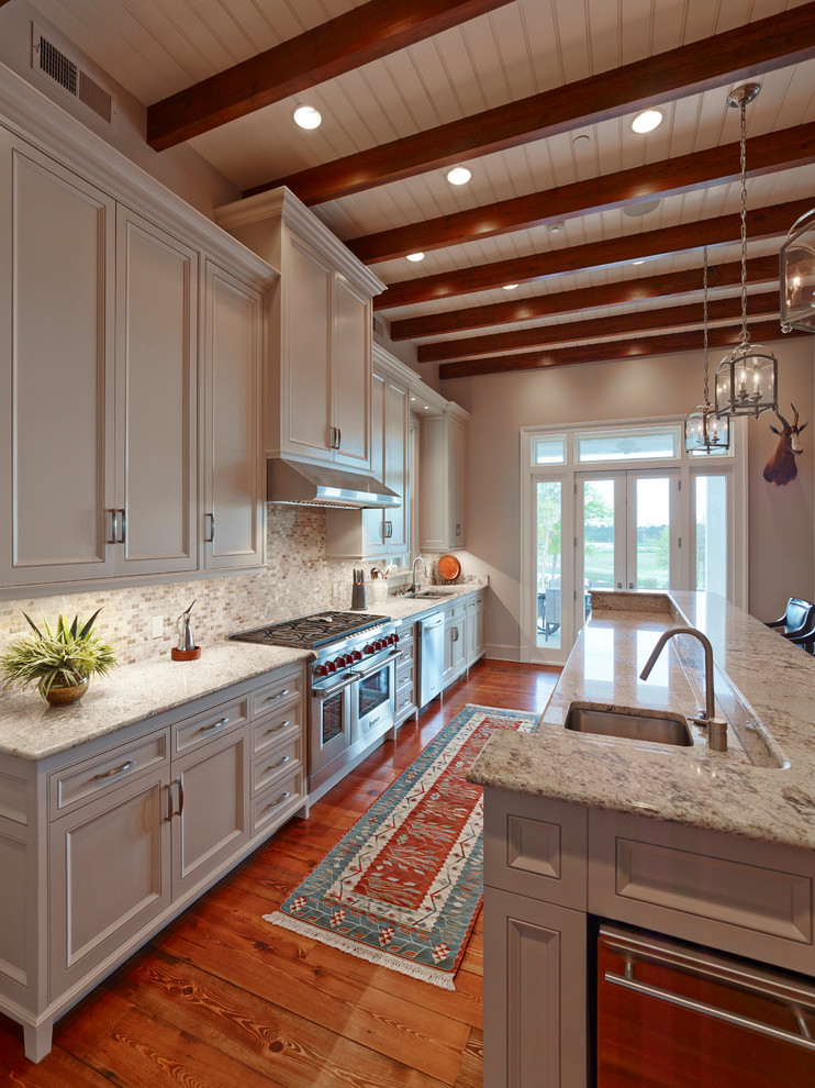 Inspiration for a traditional kitchen in New Orleans with white cabinets, granite benchtops, glass tile splashback, stainless steel appliances, medium hardwood floors and with island.