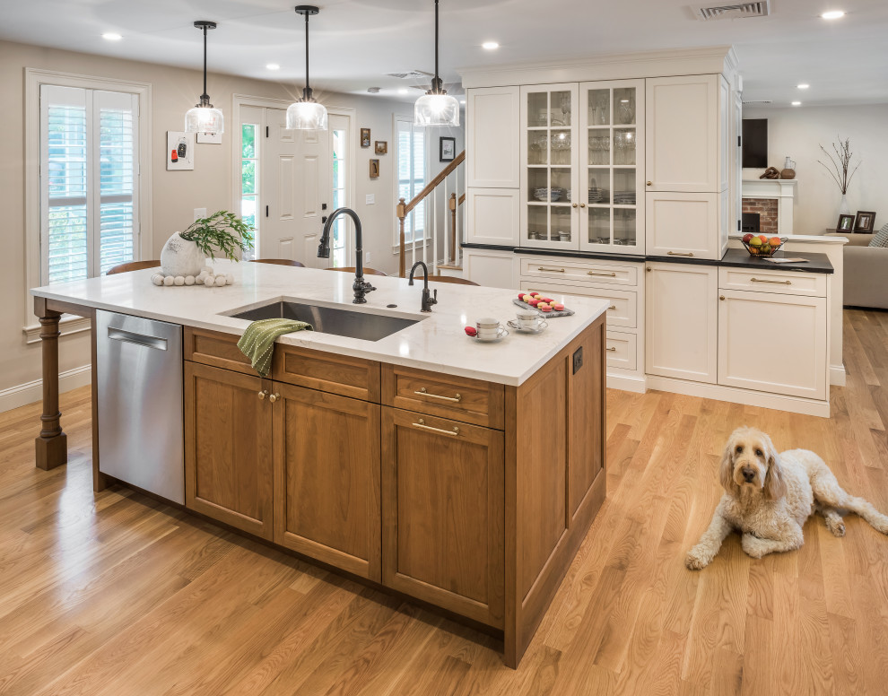 Photo of a large transitional galley eat-in kitchen in Providence with an undermount sink, shaker cabinets, white cabinets, quartz benchtops, white splashback, subway tile splashback, stainless steel appliances, medium hardwood floors, with island, brown floor and white benchtop.