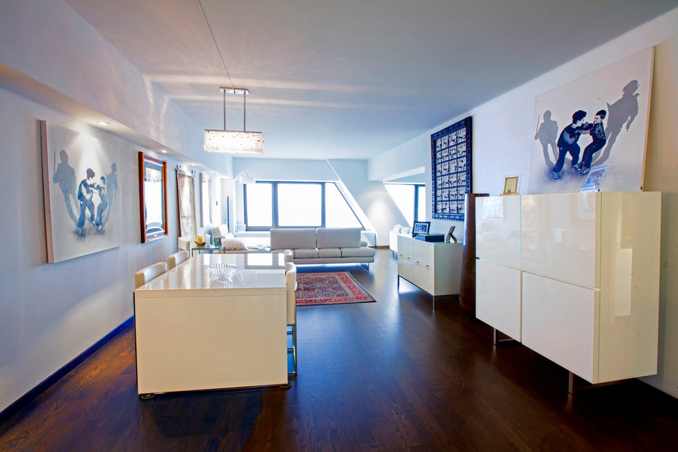 Example of a mid-sized minimalist dark wood floor and brown floor great room design in Chicago with white walls and no fireplace