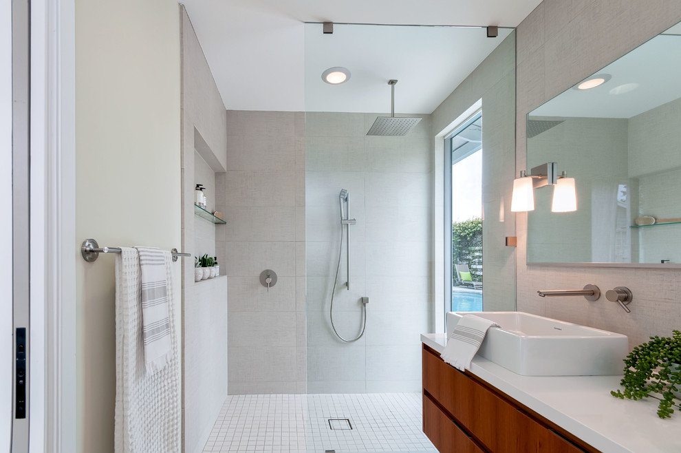 This is an example of a small contemporary master bathroom in San Diego with flat-panel cabinets, medium wood cabinets, an open shower, beige tile, porcelain tile, beige walls, porcelain floors, a vessel sink, engineered quartz benchtops and an open shower.