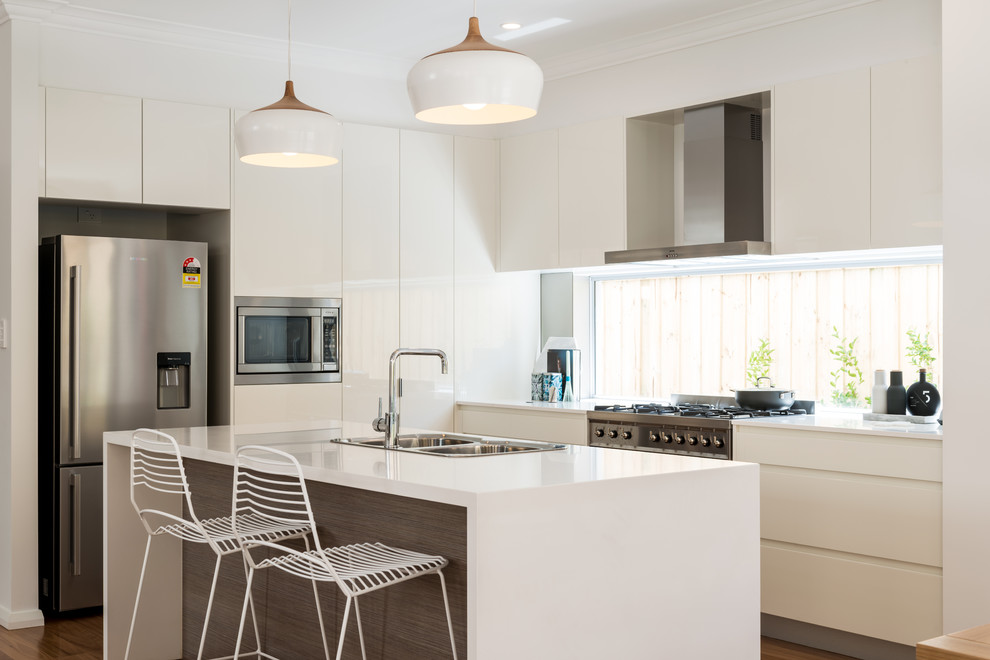 This is an example of a contemporary l-shaped kitchen in Sydney with a double-bowl sink, flat-panel cabinets, white cabinets, with island and dark hardwood floors.