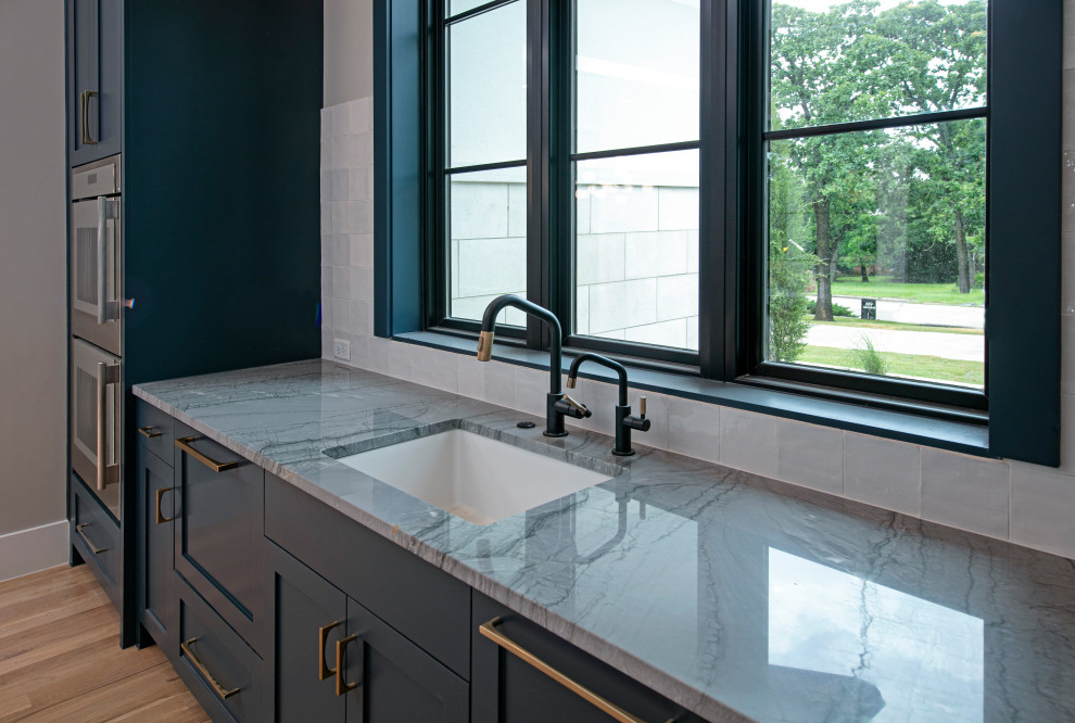 Inspiration for a large transitional u-shaped eat-in kitchen remodel in Dallas with flat-panel cabinets, dark wood cabinets, quartz countertops, white backsplash, stainless steel appliances, an island and gray countertops