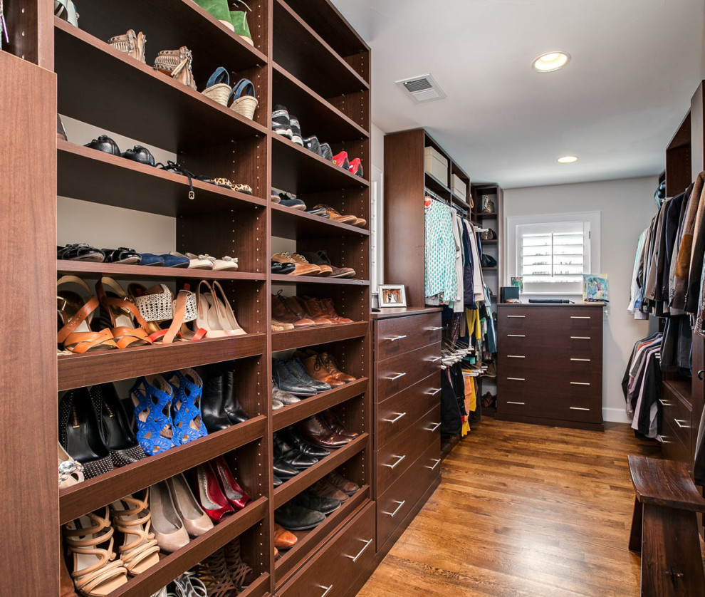 This is an example of a medium sized classic gender neutral walk-in wardrobe in Miami with flat-panel cabinets and medium hardwood flooring.