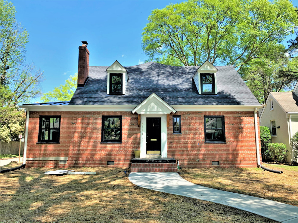 This is an example of a mid-sized traditional two-storey brick orange house exterior in Richmond with a gable roof and a shingle roof.
