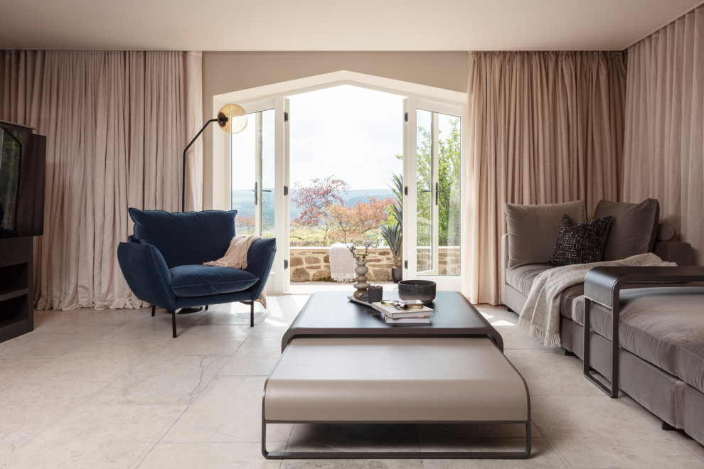 Imagen de salón cerrado minimalista de tamaño medio con chimenea de doble cara, marco de chimenea de piedra, suelo beige y cortinas