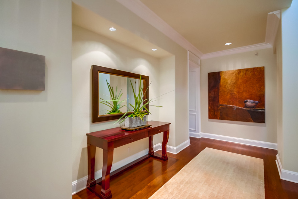 Photo of a large contemporary hallway in San Diego with beige walls, dark hardwood floors and brown floor.