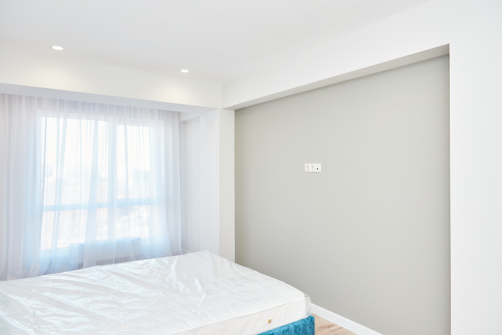 Идея дизайна: хозяйская, серо-белая спальня среднего размера, в светлых тонах в современном стиле с серыми стенами, полом из ламината, коричневым полом и обоями на стенах без камина