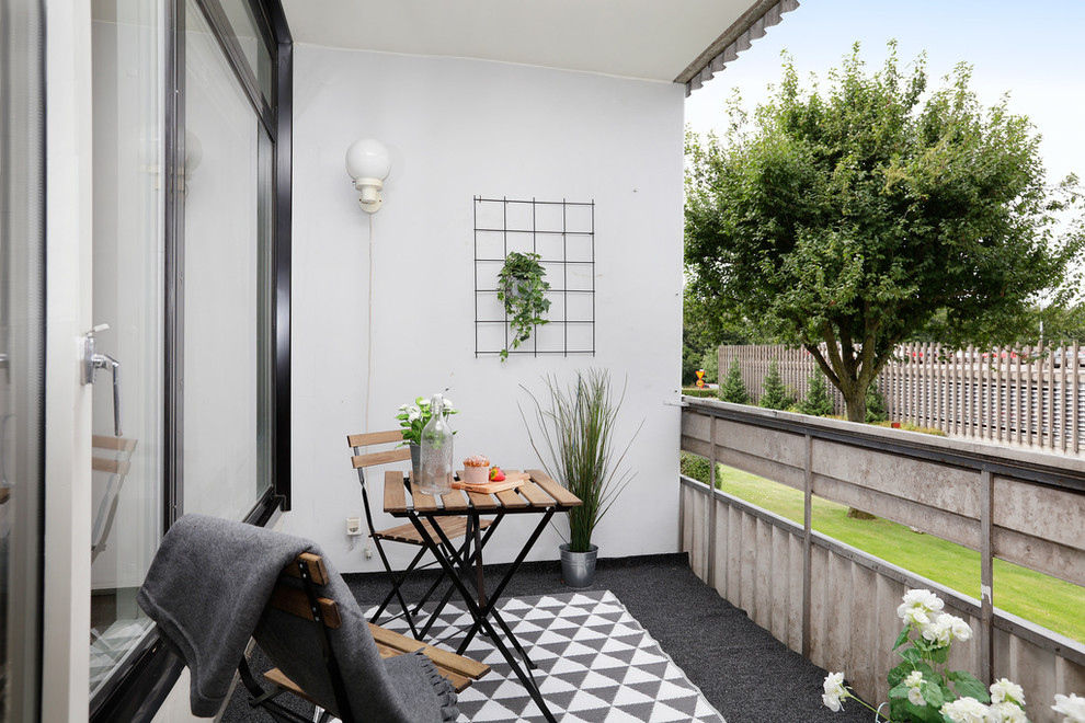 Inspiration for a scandinavian balcony in Malmo with a container garden and a roof extension.