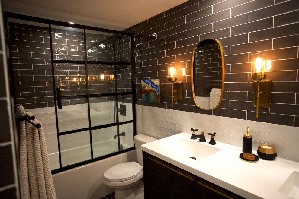 Inspiration for a small transitional master bathroom in Toronto with furniture-like cabinets, brown cabinets, an alcove tub, a shower/bathtub combo, a two-piece toilet, subway tile, multi-coloured walls, marble floors, an integrated sink, black floor, a sliding shower screen and white benchtops.