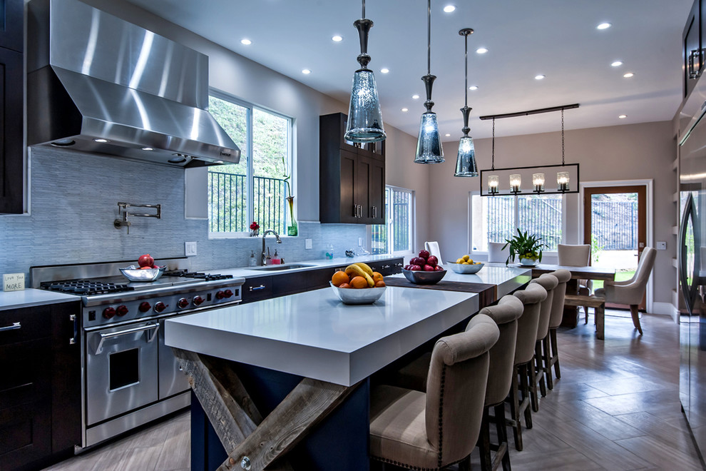 Inspiration for an expansive transitional galley eat-in kitchen in Los Angeles with an undermount sink, shaker cabinets, dark wood cabinets, quartz benchtops, white splashback, matchstick tile splashback, stainless steel appliances, marble floors, with island and brown floor.