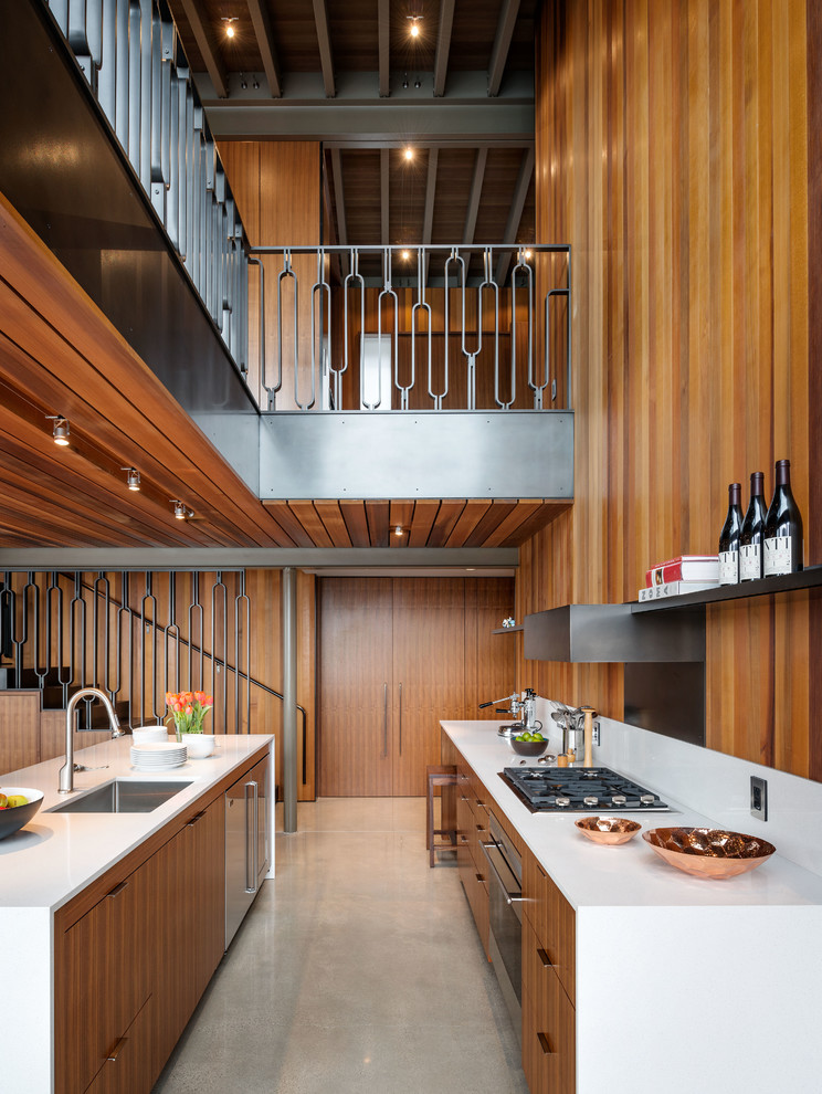 Inspiration for a large midcentury galley open plan kitchen in Seattle with an undermount sink, flat-panel cabinets, stainless steel appliances, concrete floors and with island.