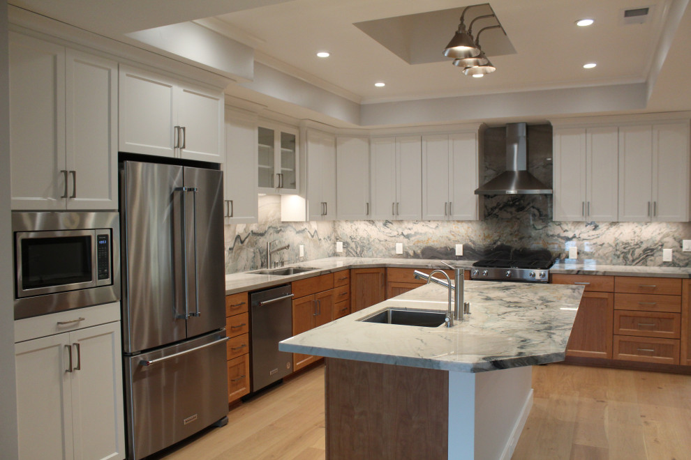 Kitchen - large transitional l-shaped medium tone wood floor, brown floor and vaulted ceiling kitchen idea in San Francisco with an undermount sink, shaker cabinets, medium tone wood cabinets, granite countertops, multicolored backsplash, stone slab backsplash, stainless steel appliances, an island and multicolored countertops