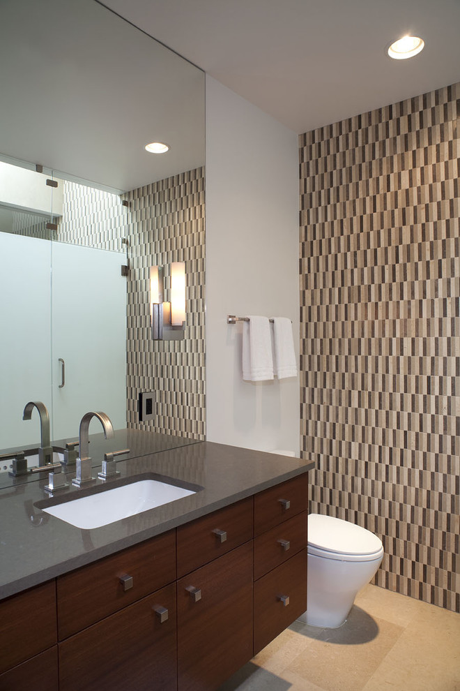 Mid-sized contemporary 3/4 bathroom in Austin with an undermount sink, flat-panel cabinets, dark wood cabinets, beige tile, mosaic tile, an alcove shower, a one-piece toilet, white walls, limestone floors and engineered quartz benchtops.