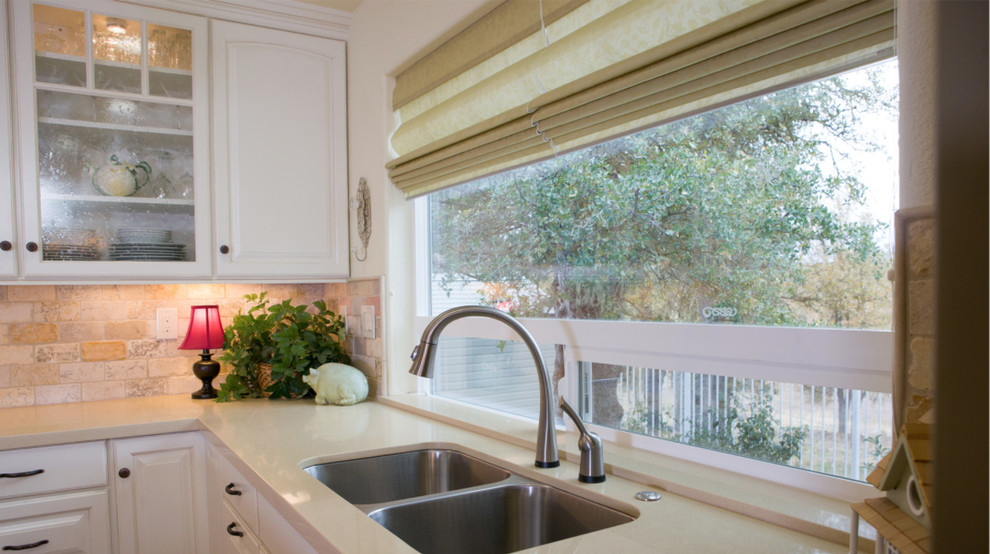 Example of a mid-sized transitional l-shaped medium tone wood floor open concept kitchen design with a double-bowl sink, raised-panel cabinets, white cabinets, white backsplash, stainless steel appliances and an island