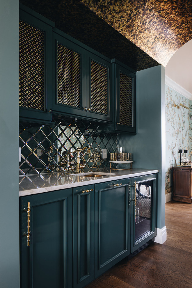 Example of a large classic galley dark wood floor and brown floor wet bar design in Other with an integrated sink, green cabinets, quartzite countertops, mirror backsplash and beige countertops