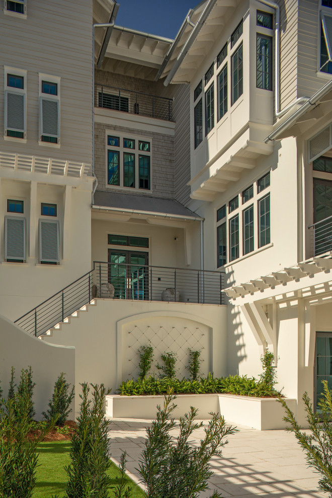 Стильный дизайн: четырехэтажный, серый частный загородный дом в морском стиле с комбинированной облицовкой, двускатной крышей, металлической крышей, серой крышей и отделкой дранкой - последний тренд