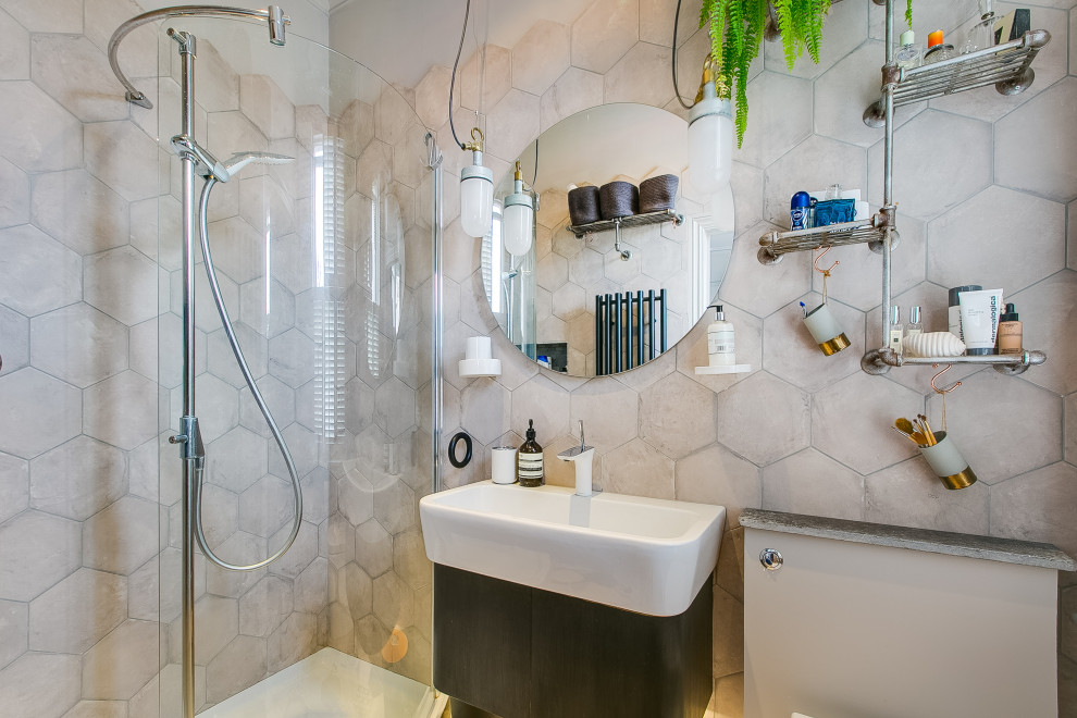 Photo of a small contemporary ensuite half tiled bathroom in London with black cabinets, a walk-in shower, beige tiles, ceramic tiles, grey walls, cement flooring, a wall-mounted sink, grey floors, an open shower, a feature wall, a single sink and a floating vanity unit.